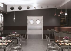 Drzwi techniczne Polskone wahadłowe z okrągłymi przeszkleniami w przestrzeni restauracyjnej